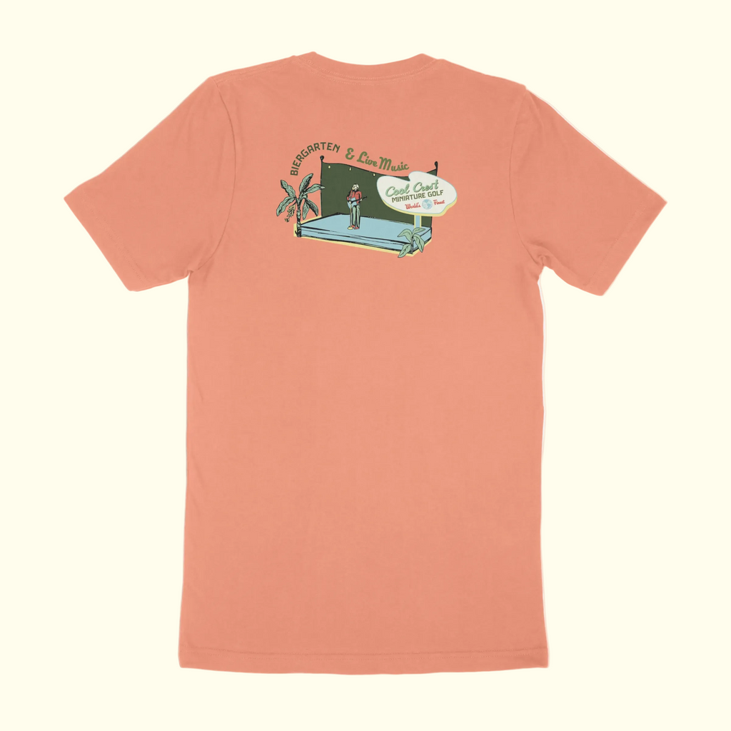 Peach-colored t-shirt with a graphic design on the back against a white background